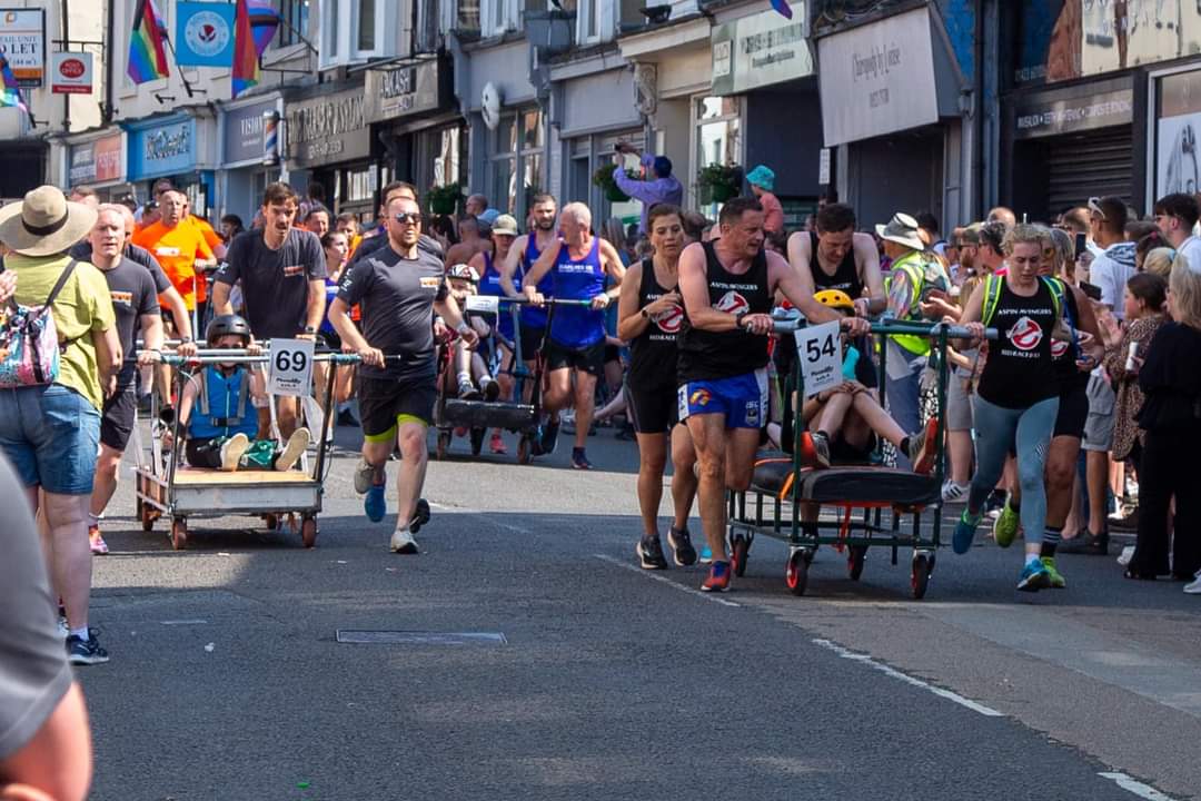 Teams racing decorated beds down a crowd-lined Knaresborough street at the Bed Race